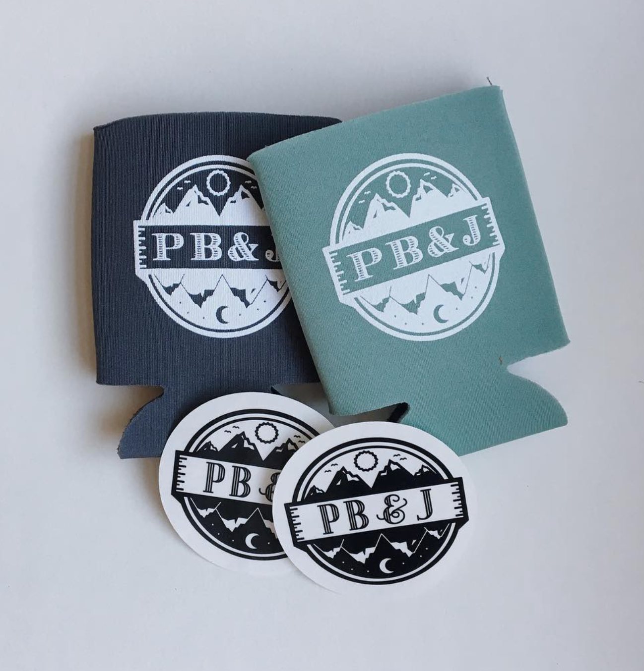 PB&J koozies in charcoal and sage with badge stickers